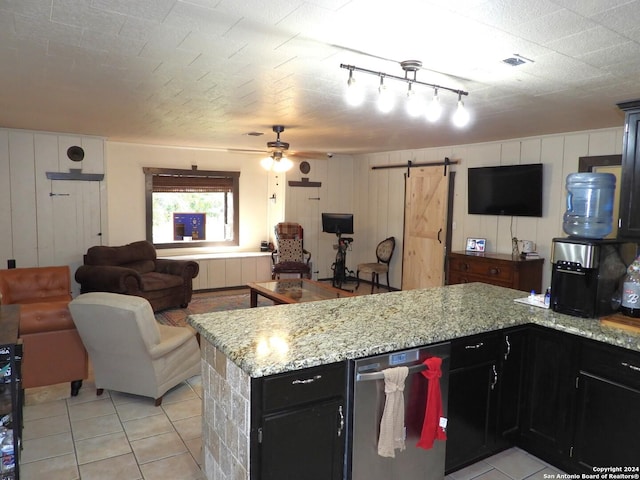 155 Scenic Cir, Lakehills, TX 78063 - kitchen with open floor plan, a barn door, light tile patterned flooring, and wood walls