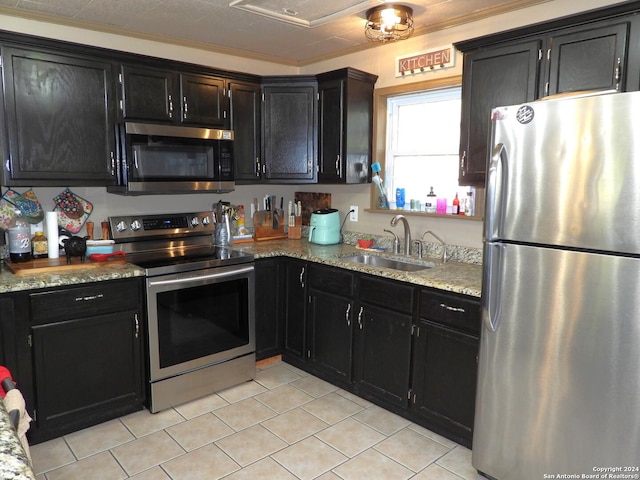 155 Scenic Cir, Lakehills, TX 78063 - kitchen with appliances with stainless steel finishes, a sink, dark cabinets, light tile patterned floors, and light stone countertops