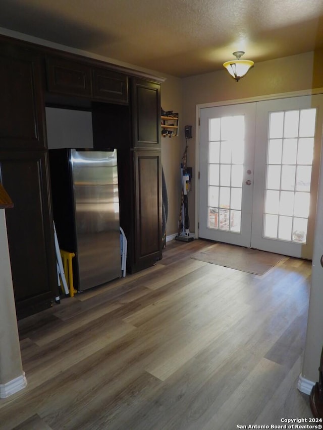 155 Scenic Cir, Lakehills, TX 78063 - kitchen featuring freestanding refrigerator, french doors, light wood-type flooring, and baseboards