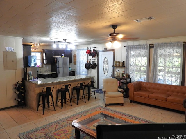 155 Scenic Cir, Lakehills, TX 78063 - living area with healthy amount of natural light, ceiling fan, electric panel, and light tile patterned floors