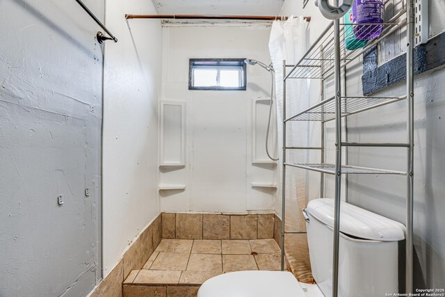 2927 Lasses, San Antonio, TX 78223 - bathroom with toilet, a shower, and stone finish flooring