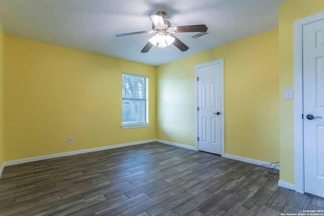 210 Cardinal, New Braunfels, TX 78130 - spare room with dark wood-style flooring, a textured ceiling, ceiling fan, and baseboards