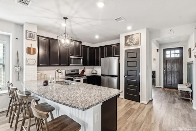4902 Oxbow Bnd, Saint Hedwig, TX 78152 - kitchen with appliances with stainless steel finishes, a sink, a peninsula, light stone counters, and recessed lighting