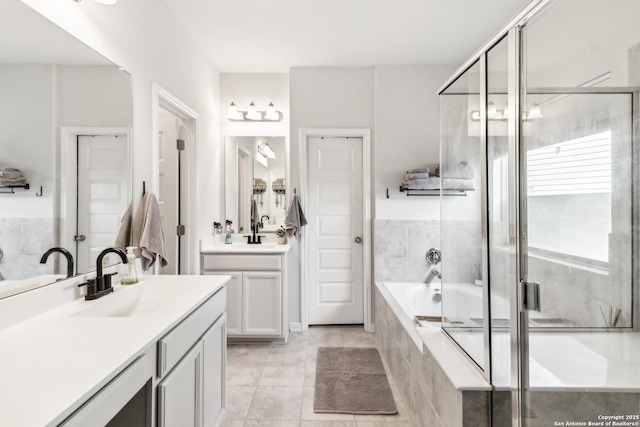 4902 Oxbow Bnd, Saint Hedwig, TX 78152 - full bath with two vanities, a relaxing tiled tub, an enclosed shower, and tile patterned floors