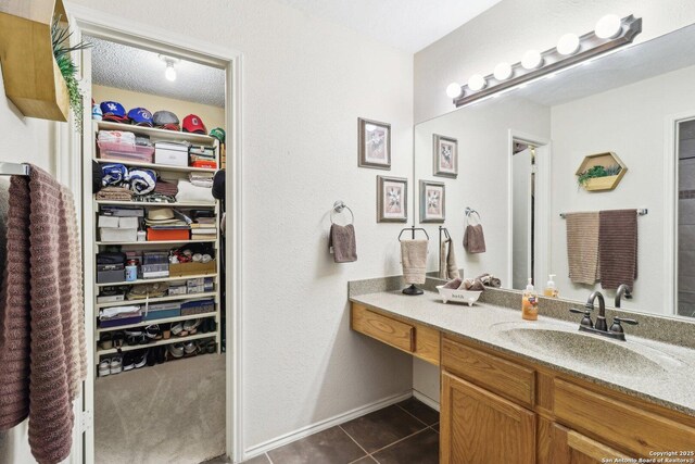 14026 Fairway Oaks, San Antonio, TX 78217 - bathroom with vanity, tile patterned flooring, a walk in closet, and baseboards