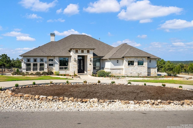1132 Towhee Trl, New Braunfels, TX 78132 - view of front facade featuring stone siding, a chimney, and roof with shingles