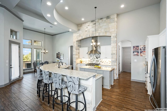 1132 Towhee Trl, New Braunfels, TX 78132 - kitchen with a chandelier, freestanding refrigerator, a large island with sink, arched walkways, and recessed lighting