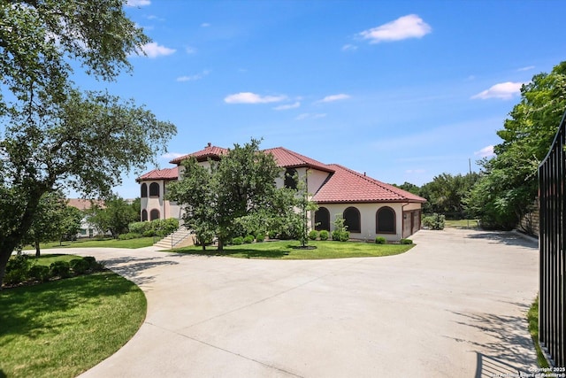 427 Bella Montagna Cir, Austin, TX 78734 - mediterranean / spanish house with a tile roof, stucco siding, curved driveway, and a front lawn