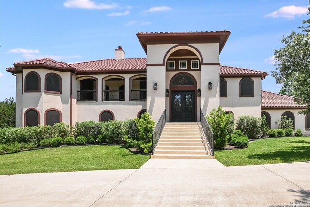 427 Bella Montagna Cir, Austin, TX 78734 - mediterranean / spanish-style house featuring a front lawn, stucco siding, a chimney, and a tile roof