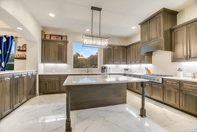 427 Bella Montagna Cir, Austin, TX 78734 - kitchen featuring light countertops, stainless steel gas stovetop, light marble finish flooring, a center island, and recessed lighting