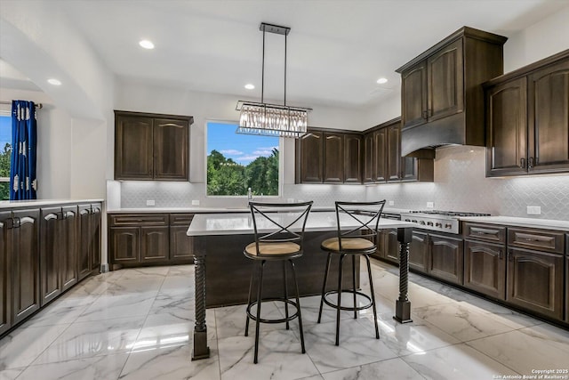 427 Bella Montagna Cir, Austin, TX 78734 - kitchen with light marble finish flooring, stainless steel gas stovetop, dark brown cabinetry, light countertops, and tasteful backsplash