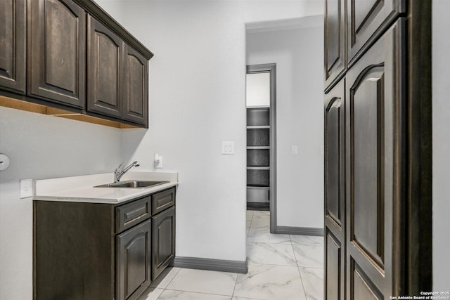 427 Bella Montagna Cir, Austin, TX 78734 - laundry area featuring light marble finish floors, baseboards, and cabinet space