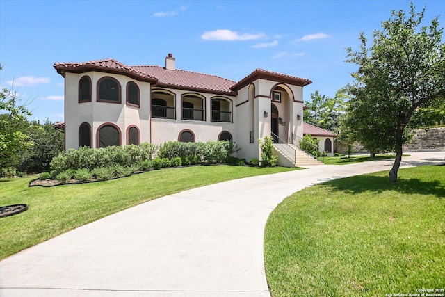 427 Bella Montagna Cir, Austin, TX 78734 - view of front of house featuring a chimney, stucco siding, a tile roof, and a front yard