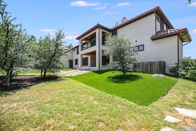 427 Bella Montagna Cir, Austin, TX 78734 - rear view of property featuring a balcony, a tiled roof, stucco siding, and a chimney