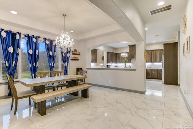 427 Bella Montagna Cir, Austin, TX 78734 - dining space featuring baseboards, a chandelier, arched walkways, recessed lighting, and light marble finish flooring