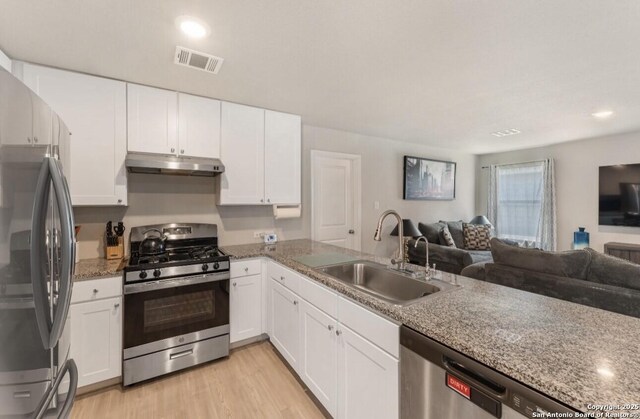 734 Ambush Rdg, San Antonio, TX 78219 - kitchen with stainless steel appliances, under cabinet range hood, a sink, open floor plan, and white cabinetry