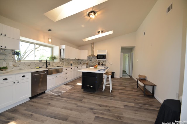 3160 Weil, Marion, TX 78124 - kitchen with a skylight, appliances with stainless steel finishes, wall chimney range hood, decorative backsplash, and a sink