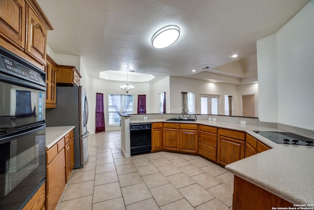 3343 Dove Park Ln, San Antonio, TX 78253 - kitchen featuring black appliances, brown cabinetry, a chandelier, light countertops, and a sink