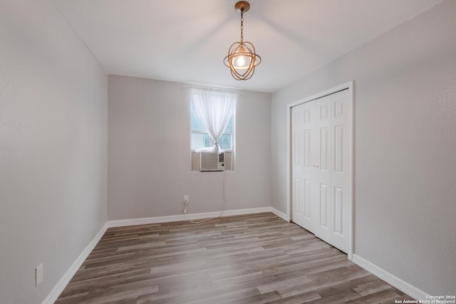 1129 N Smith St, San Antonio, TX 78207 - unfurnished bedroom featuring wood finished floors, baseboards, a closet, and cooling unit