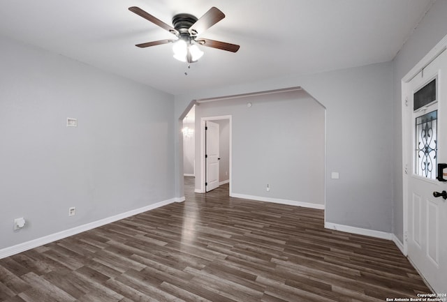1129 N Smith St, San Antonio, TX 78207 - empty room featuring arched walkways, dark wood-style flooring, ceiling fan, and baseboards