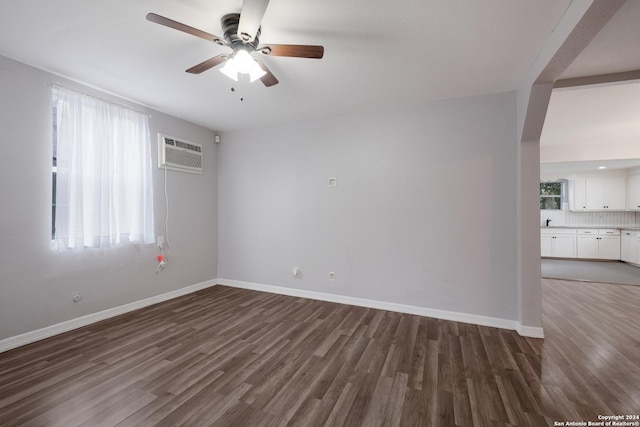 1129 N Smith St, San Antonio, TX 78207 - unfurnished room featuring a ceiling fan, wood finished floors, a wall unit AC, and baseboards