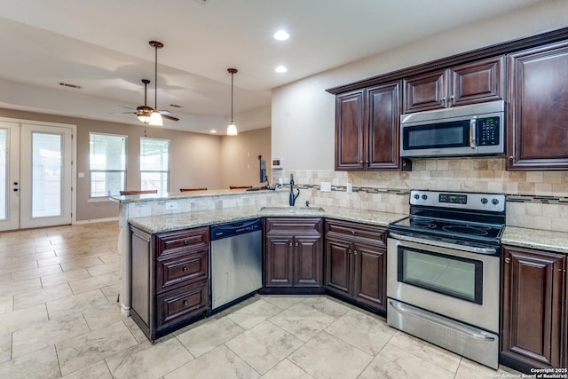 712 Crestview, Floresville, TX 78114 - kitchen featuring appliances with stainless steel finishes, a sink, backsplash, a peninsula, and ceiling fan