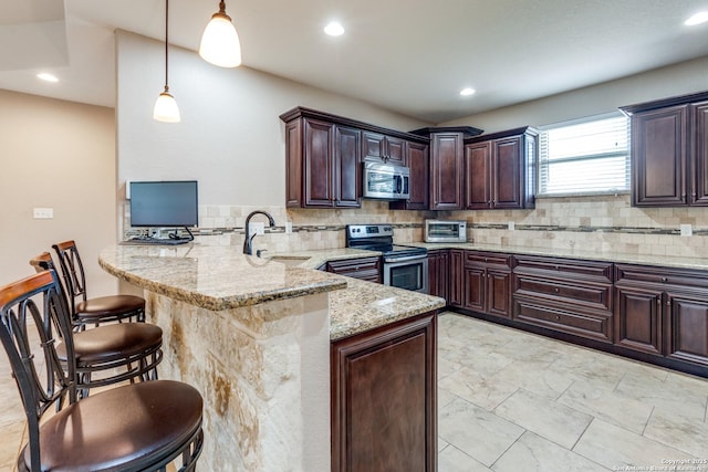 712 Crestview, Floresville, TX 78114 - kitchen with stainless steel appliances, a sink, a peninsula, decorative backsplash, and a kitchen breakfast bar