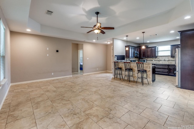 712 Crestview, Floresville, TX 78114 - kitchen with stainless steel appliances, open floor plan, a tray ceiling, a kitchen breakfast bar, and recessed lighting