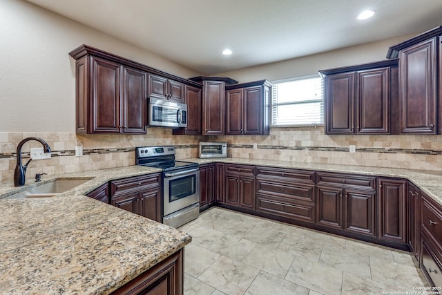 712 Crestview, Floresville, TX 78114 - kitchen featuring appliances with stainless steel finishes, a sink, backsplash, light stone countertops, and recessed lighting