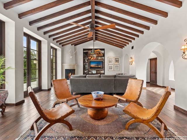2835 Palomino Spgs, Bandera, TX 78003 - living room featuring wood-type flooring, baseboards, arched walkways, and a lit fireplace