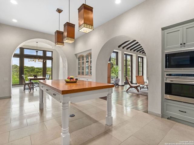 2835 Palomino Spgs, Bandera, TX 78003 - kitchen featuring stainless steel oven, black microwave, arched walkways, wooden counters, and a chandelier