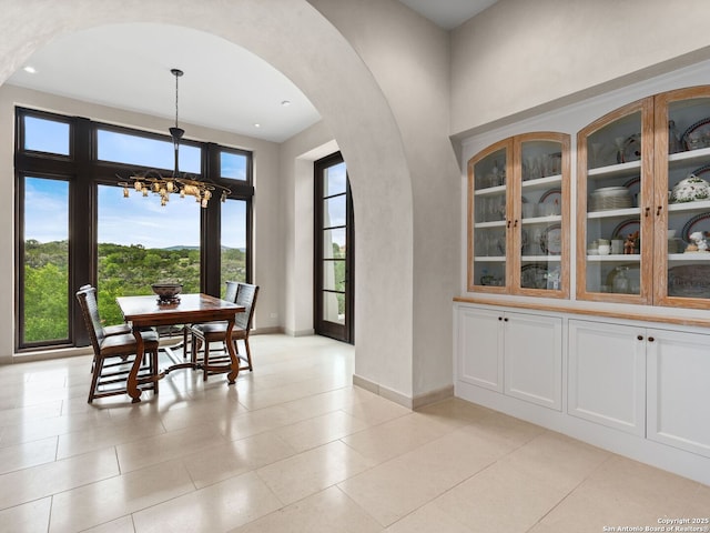 2835 Palomino Spgs, Bandera, TX 78003 - dining room with arched walkways, a chandelier, baseboards, and light tile patterned flooring