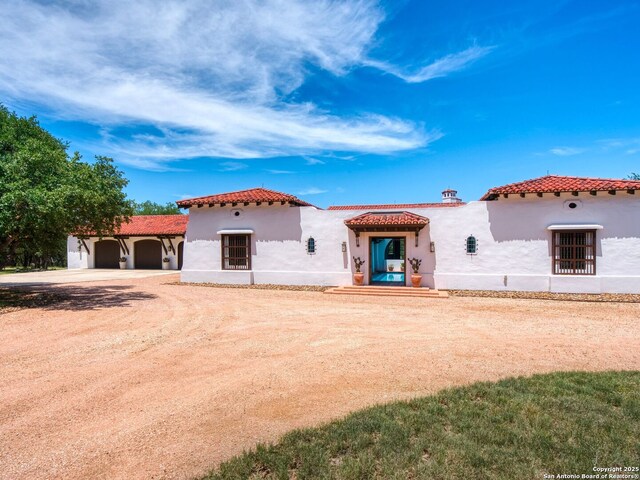 2835 Palomino Spgs, Bandera, TX 78003 - mediterranean / spanish-style home featuring a tile roof, stucco siding, and driveway