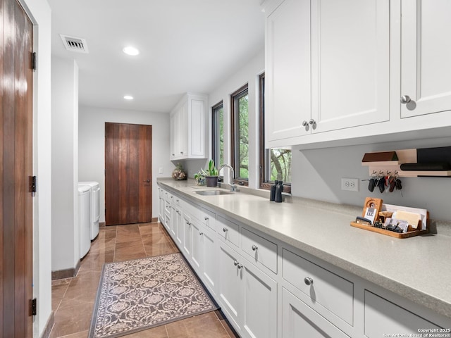 2835 Palomino Spgs, Bandera, TX 78003 - kitchen with a sink, light countertops, recessed lighting, washer and dryer, and white cabinetry