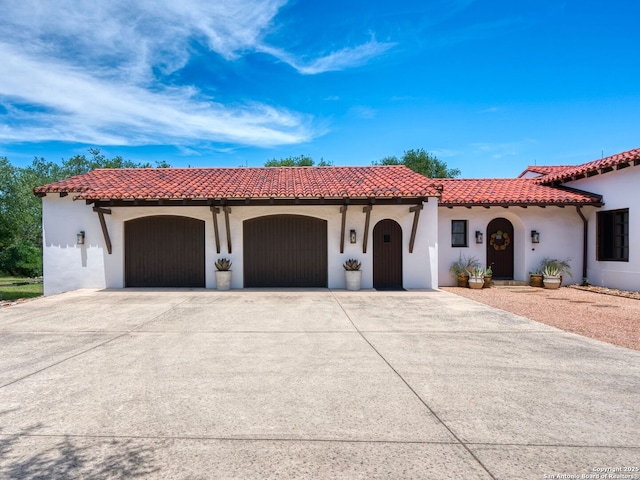 2835 Palomino Spgs, Bandera, TX 78003 - mediterranean / spanish house featuring an attached garage, driveway, a tile roof, and stucco siding