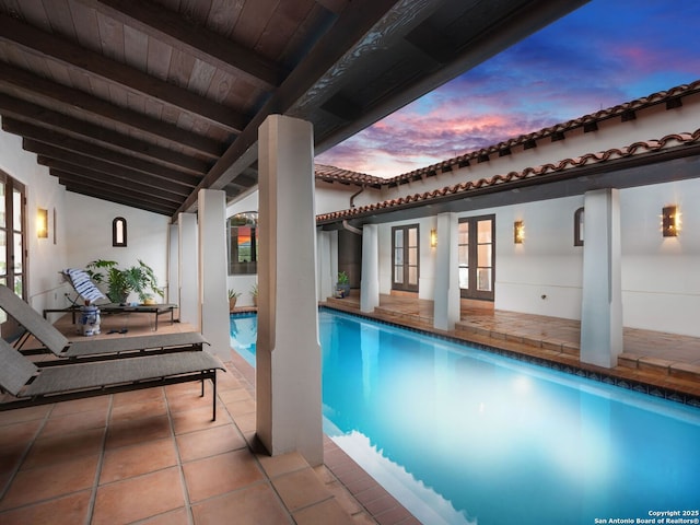 2835 Palomino Spgs, Bandera, TX 78003 - pool at dusk with french doors, an outdoor pool, and a patio