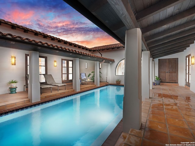 2835 Palomino Spgs, Bandera, TX 78003 - pool at dusk with french doors, an outdoor pool, and a patio