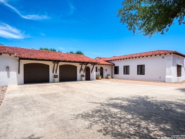 2835 Palomino Spgs, Bandera, TX 78003 - mediterranean / spanish-style home featuring stucco siding, a garage, a tiled roof, and concrete driveway