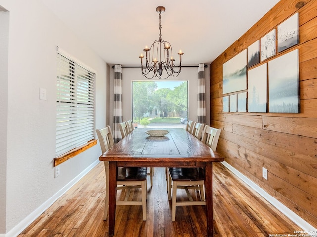 221 Harmon, San Antonio, TX 78209 - dining space with a chandelier, light wood-style flooring, baseboards, and wood walls