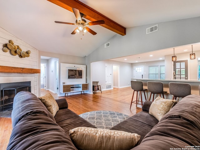 221 Harmon, San Antonio, TX 78209 - living area with beam ceiling, light wood-type flooring, ceiling fan, a large fireplace, and baseboards