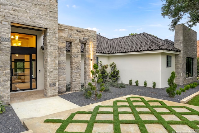 6 Turin Ct, San Antonio, TX 78257 - doorway to property with stucco siding, stone siding, and a chimney