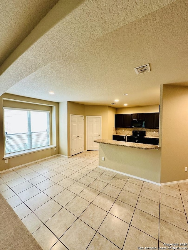 4602 Todds Farm, San Antonio, TX 78244 - kitchen with light tile patterned floors, recessed lighting, a textured ceiling, baseboards, and a peninsula