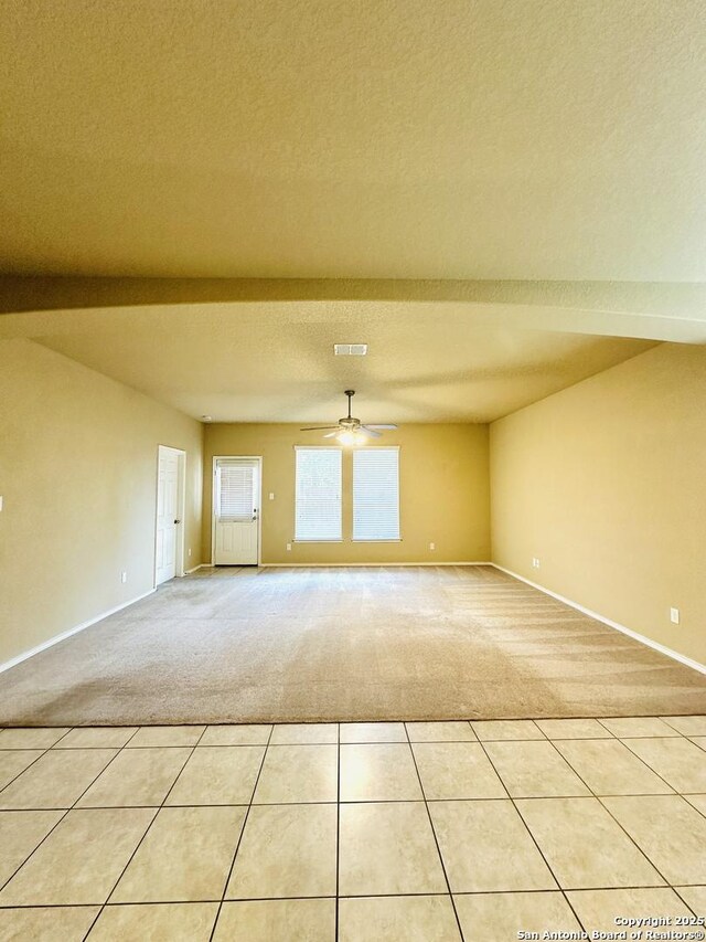 4602 Todds Farm, San Antonio, TX 78244 - empty room with light colored carpet, ceiling fan, baseboards, a textured ceiling, and light tile patterned flooring