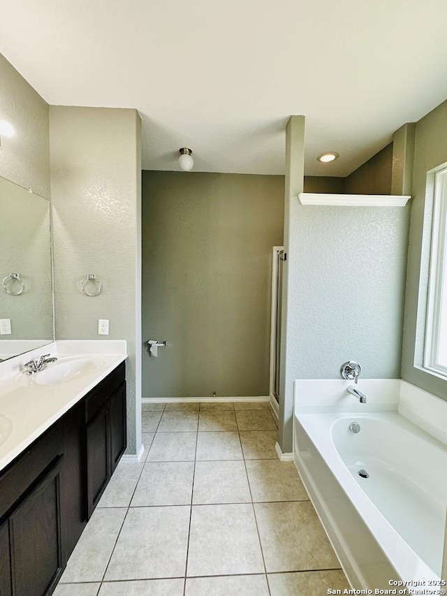 4602 Todds Farm, San Antonio, TX 78244 - full bathroom featuring tile patterned floors, double vanity, a garden tub, baseboards, and a textured wall