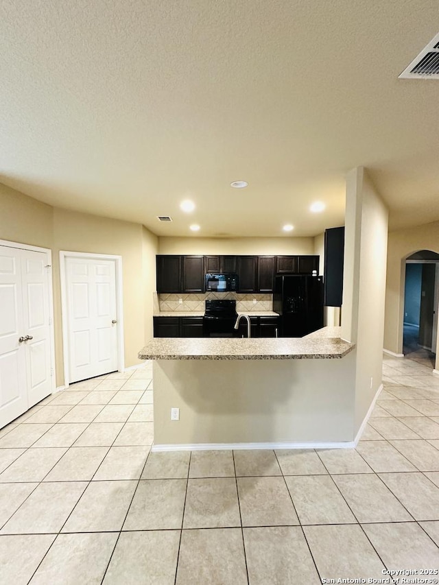 4602 Todds Farm, San Antonio, TX 78244 - kitchen with black appliances, light tile patterned flooring, arched walkways, recessed lighting, and backsplash
