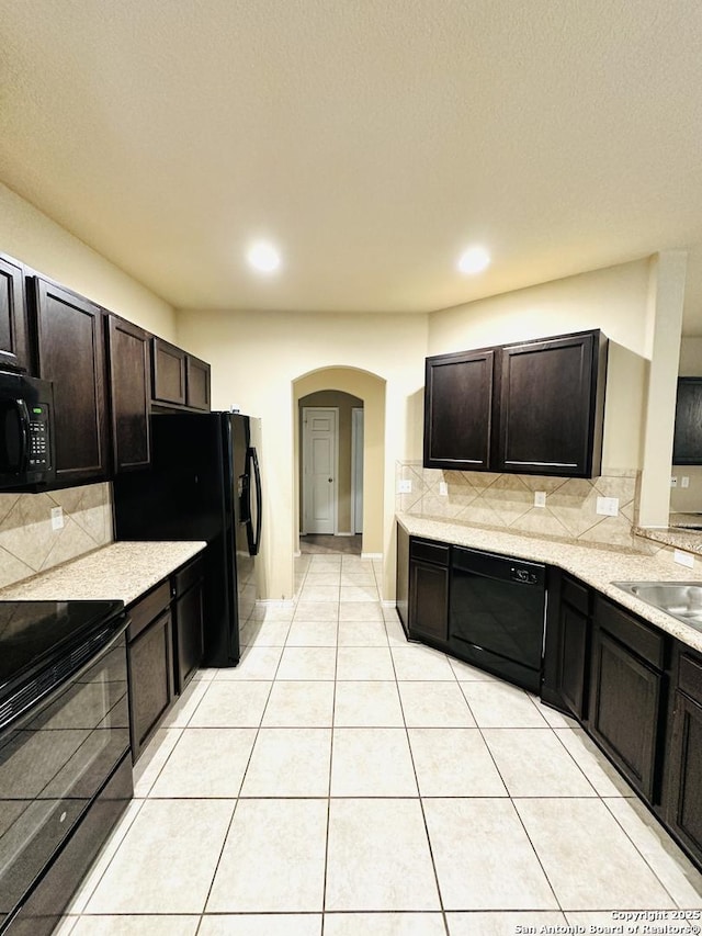 4602 Todds Farm, San Antonio, TX 78244 - kitchen featuring black appliances, arched walkways, decorative backsplash, light countertops, and light tile patterned floors