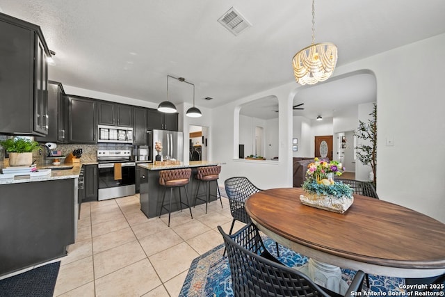 788 San Luis, New Braunfels, TX 78132 - dining area featuring light tile patterned floors, a chandelier, and arched walkways