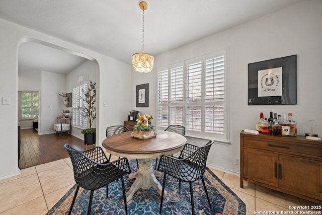 788 San Luis, New Braunfels, TX 78132 - dining area featuring a chandelier, arched walkways, light tile patterned flooring, and baseboards