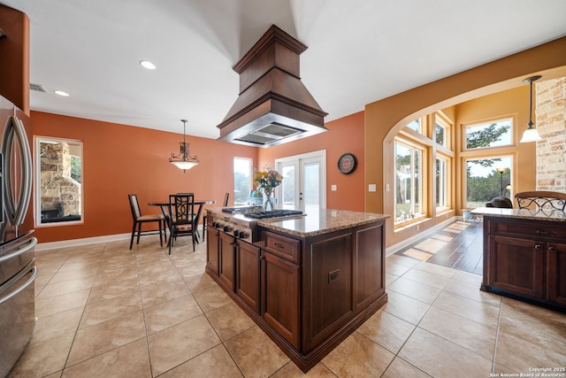 22355 Fossil, San Antonio, TX 78261 - kitchen featuring stainless steel appliances, arched walkways, light stone counters, light tile patterned flooring, and dark brown cabinetry