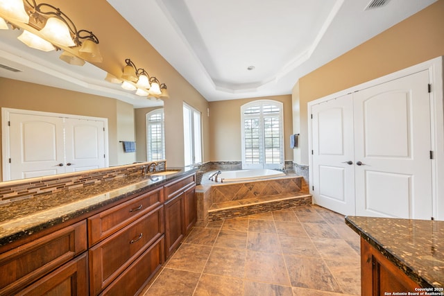 22355 Fossil, San Antonio, TX 78261 - bathroom with a tray ceiling, a garden tub, and vanity